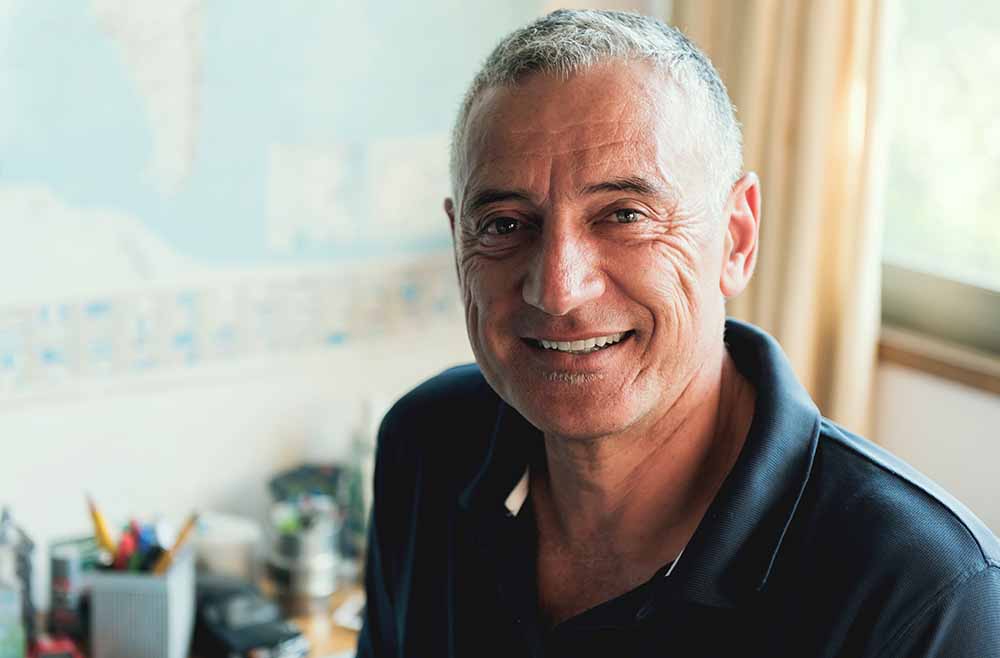 Confident implant denture patient smiling after treatment at Ressler Dental